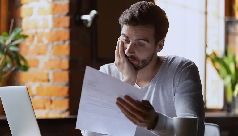 hombre leyendo papeles para ver si tiene que pagar para conseguir el atestado policial